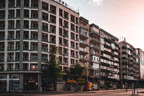 Free A cityscape showcasing modern apartment buildings along a bustling street during sunset. Stock Photo
