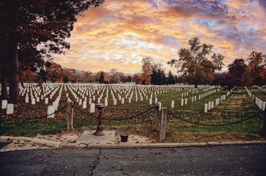 Serene view of Arlington National Cemetery under a vibrant autumn sunrise sky.