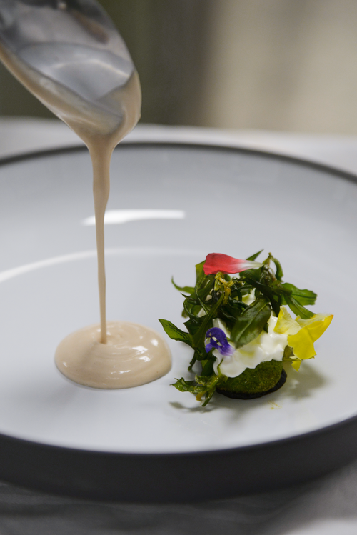 Free Artistic presentation of greens with sauce on a plate, highlighting culinary precision. Stock Photo