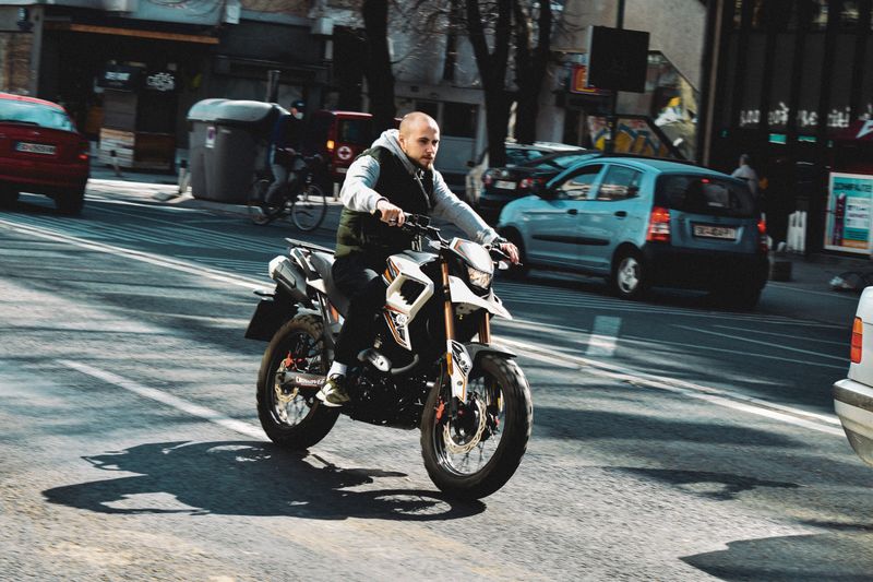 A motorcyclist skillfully maneuvers through the bustling streets of Skopje, North Macedonia.