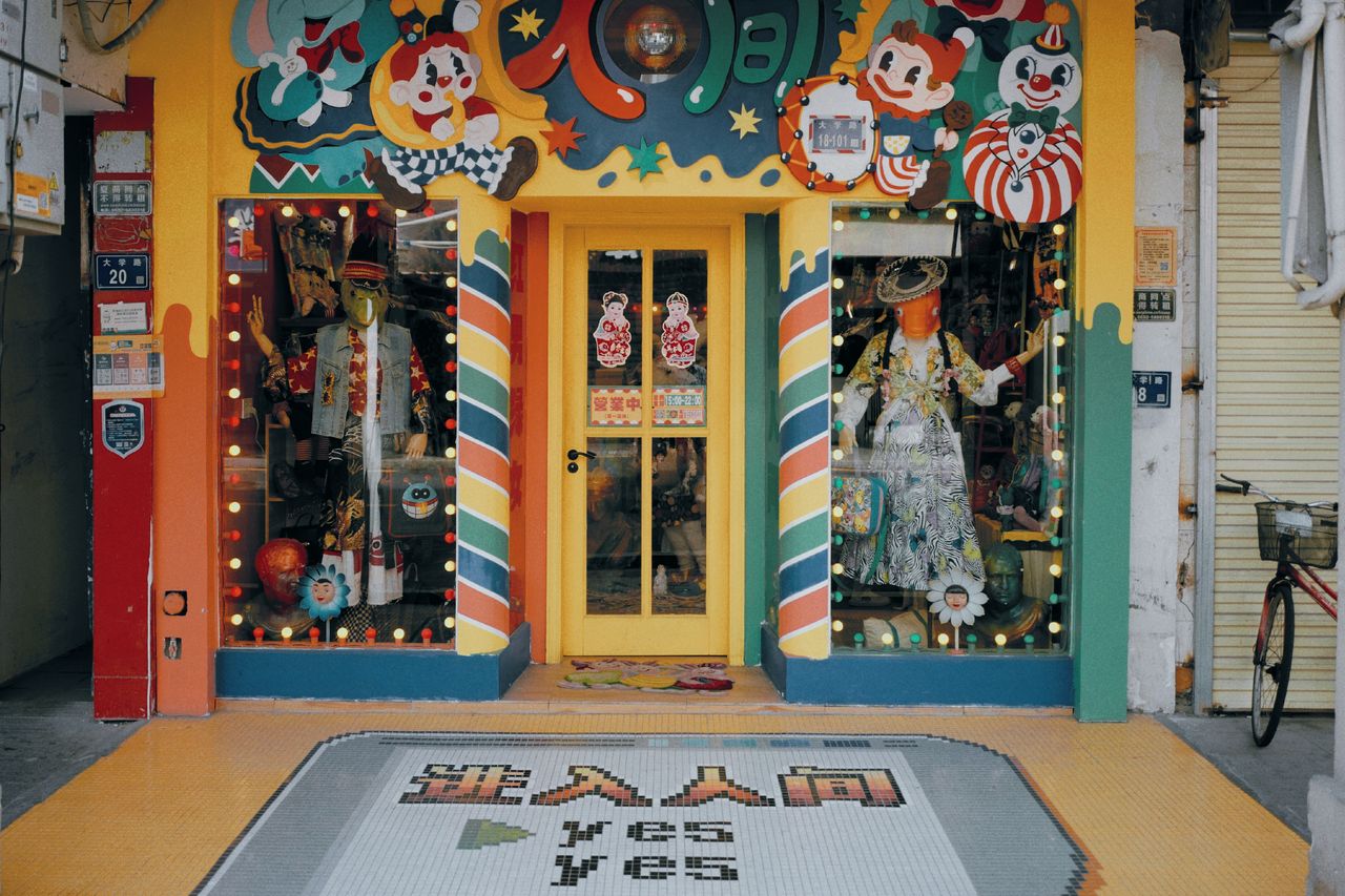 a colorful storefront with clown decorations and vibrant shop window d