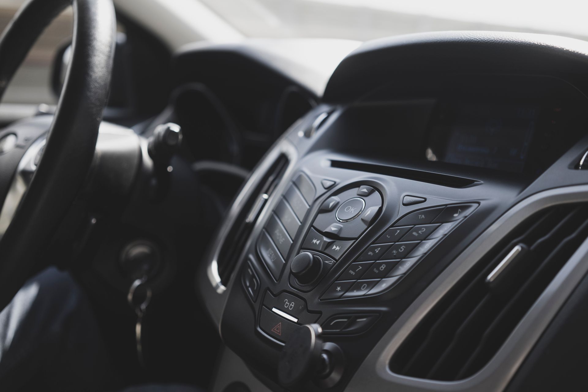 Close-up view of a modern car interior focusing on the dashboard and steering wheel.