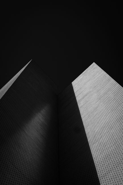 Stunning contrast of skyscraper architecture captured in black and white from a low angle, highlighting sharp lines and shadows.