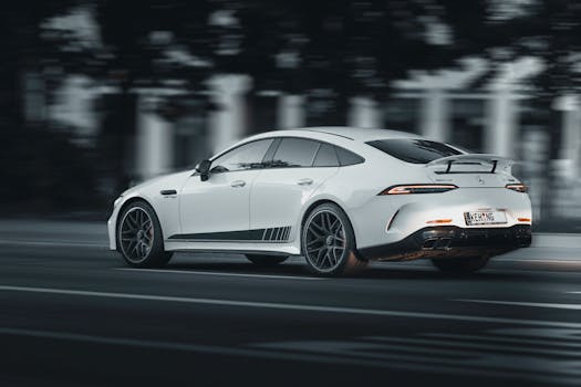 White luxury sports car speeding on a road, capturing motion and performance.