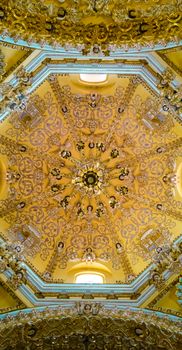 Intricate golden Baroque ceiling inside a landmark church in Cholula, Mexico.