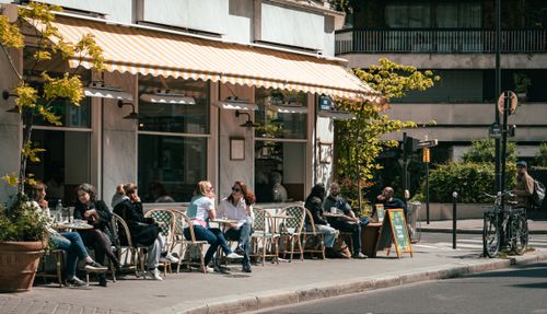 Free Relaxing scene at an outdoor cafe with people enjoying sunny day on a city street. Stock Photo
