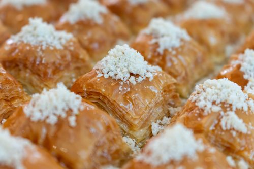 Free Enticing close-up shot of freshly baked baklava, showcasing its layers of flaky pastry and nut topping. Stock Photo