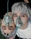 Man in White Crew Neck Shirt With Green and Silver Mask