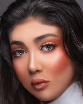 Close-up portrait of a woman with stunning makeup and captivating eyes.