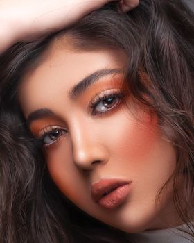 Artistic close-up portrait highlighting vibrant makeup and expressive eyes.