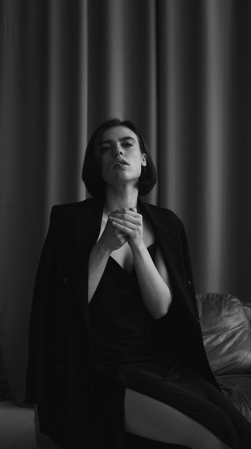 Free Black and white portrait of a woman posing elegantly in a fashion-forward outfit. Stock Photo