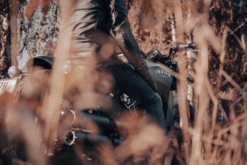 Free A motorcyclist travels through the autumn forest in Trutnov, Czechia, on a classic Indian motorcycle. Stock Photo