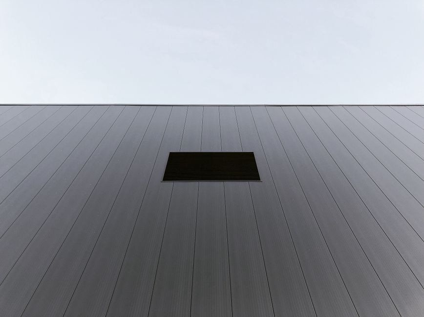 A minimalist modern room with floor-to-ceiling glass windows, showing crystal-clear light refraction on white surfaces.