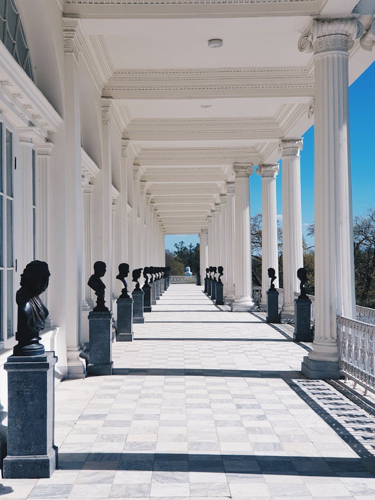 Perspective Of A Terrace With White Columns And Black Busts