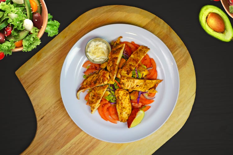 Top View Of Grilled Chicken Breasts And Sliced Tomatoes