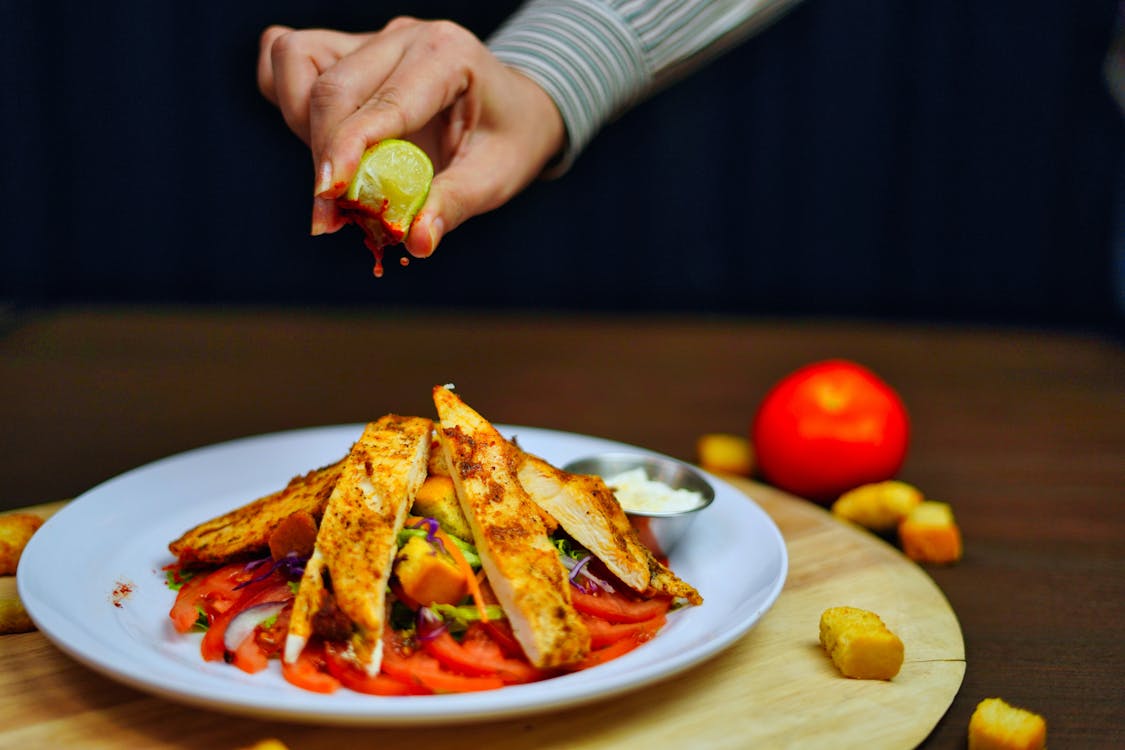 squeezing lime on chicken fajita bowl