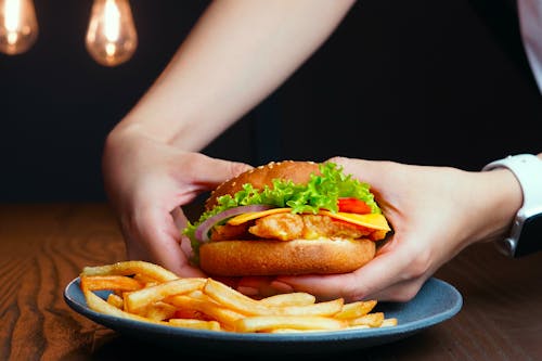 A Person Holding Hamburger with Lettuce