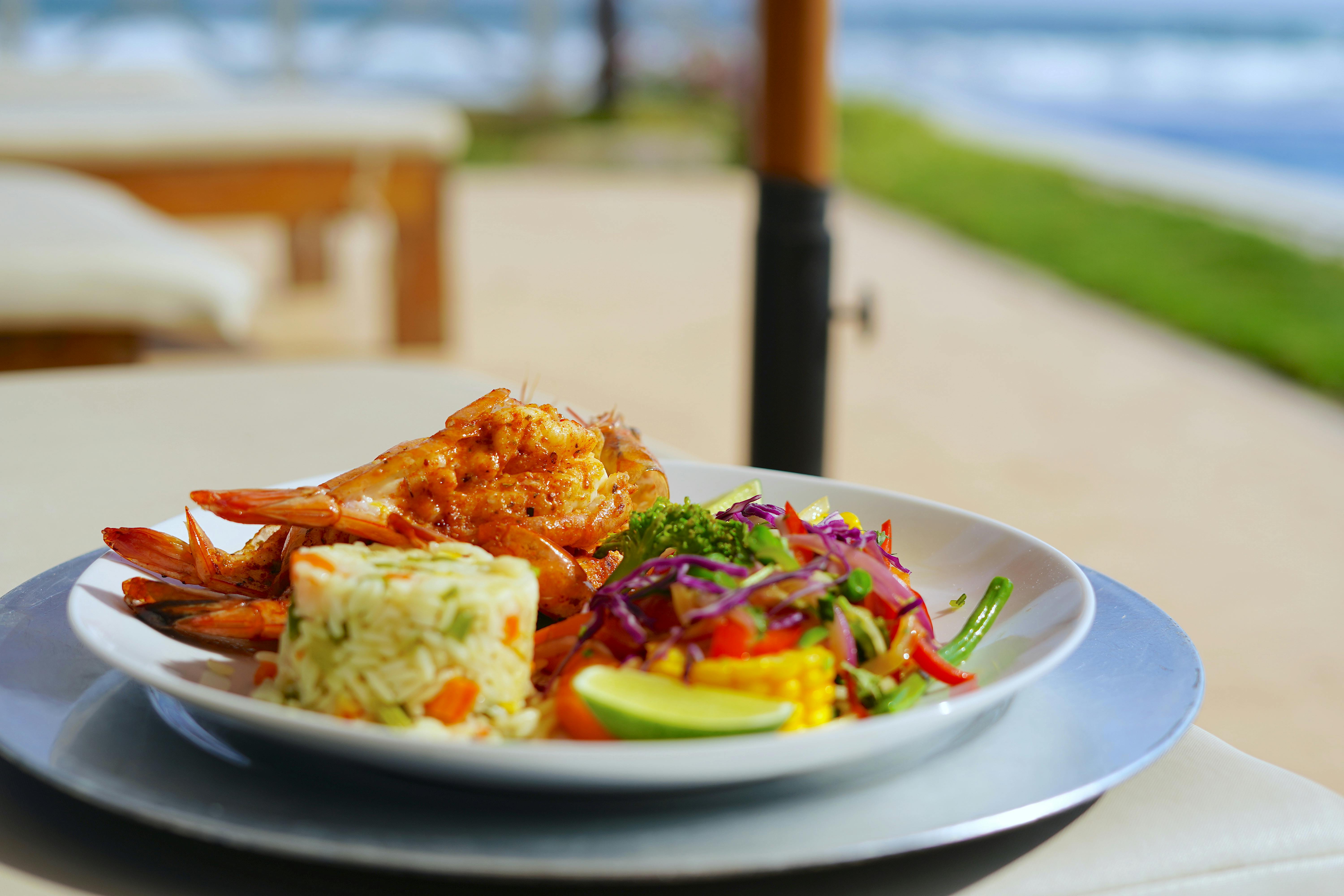 Delicious seafood plate with rice and vegetables, perfect for a sunny beachside meal.