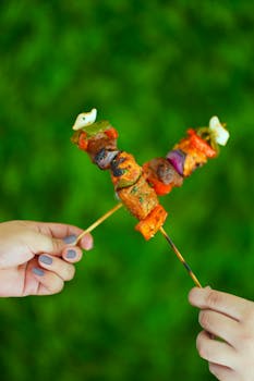 Deliciously grilled skewers of chicken and vegetables against a vibrant green background.