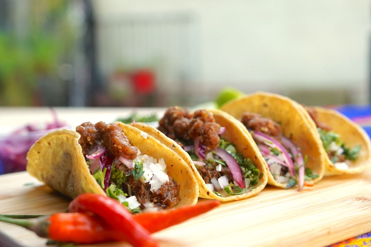 Close-up of shredded beef tacos topped with fresh onions and cilantro