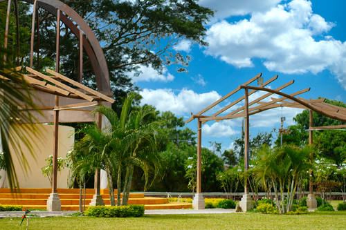 Free Scenic view of wooden pavilions in a lush park under a blue sky in El Salvador. Stock Photo