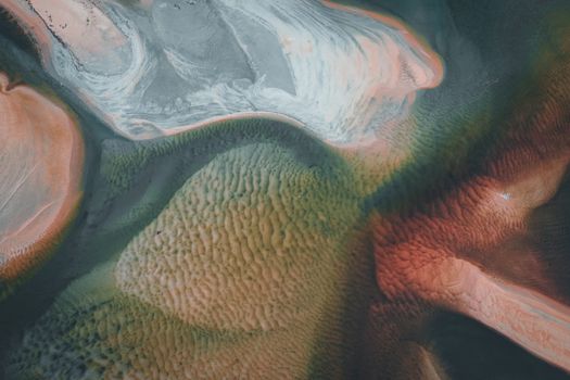 Stunning aerial shot of colorful sand patterns resembling abstract artwork.