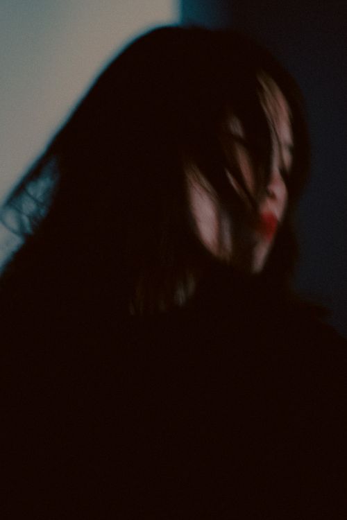 Free Blurry artistic portrait capturing a woman in motion with dark colors and modern style. Stock Photo