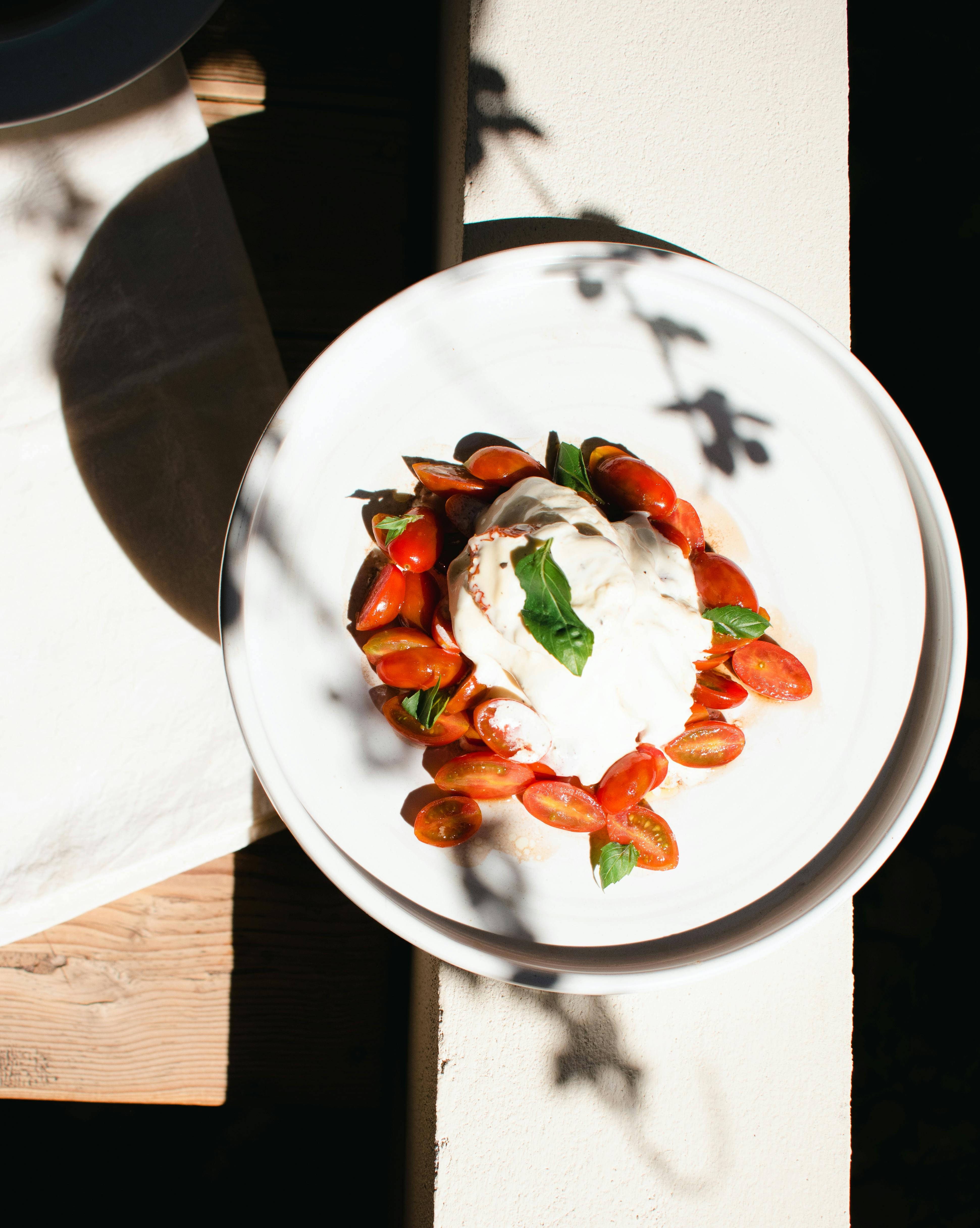 Top view of a vibrant Caprese salad on a plate with cherry tomatoes, mozzarella, and fresh basil.