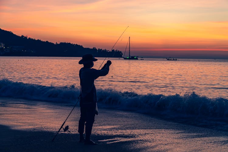 Man Fixing The Fishing Rod On Shore 