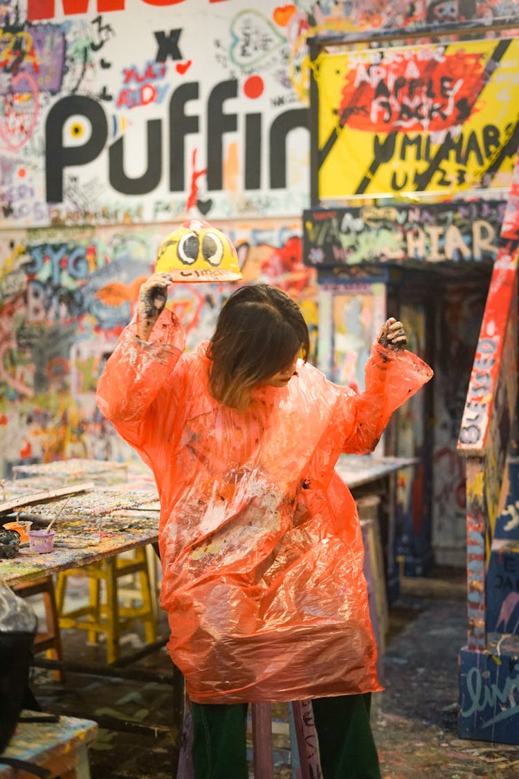 Woman In Raincoat Holding Her HardHat