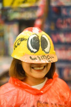 A close-up shot of a smiling woman wearing a vibrantly painted hardhat.