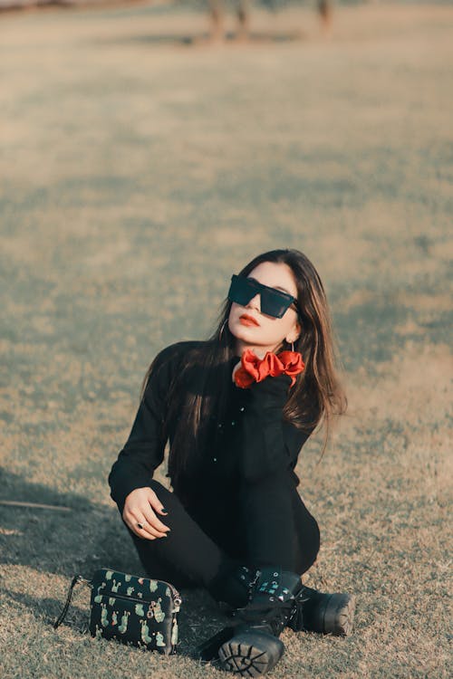 Woman with Black Sunglasses Sitting on Grass