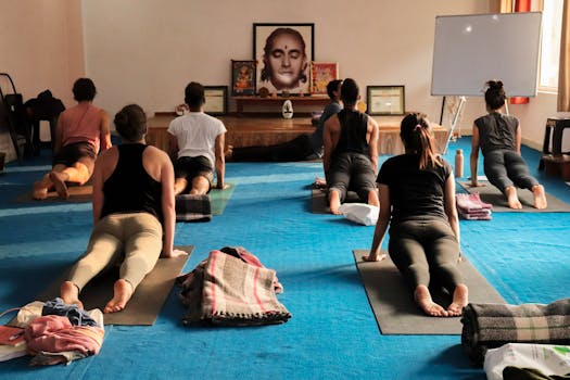 Group yoga session practicing Upward-Facing Dog Pose indoors in Rishikesh, India.