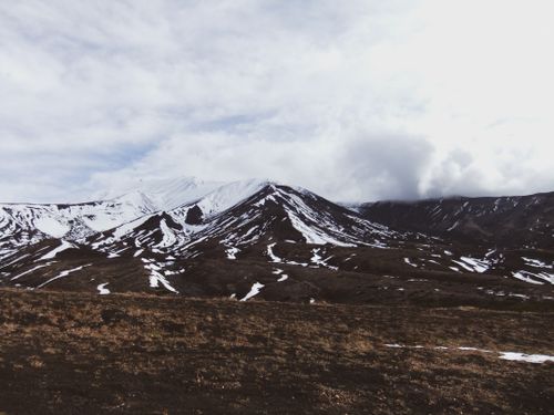Free Explore a breathtaking snow-covered mountain under a cloudy sky, showcasing winter's natural beauty. Stock Photo
