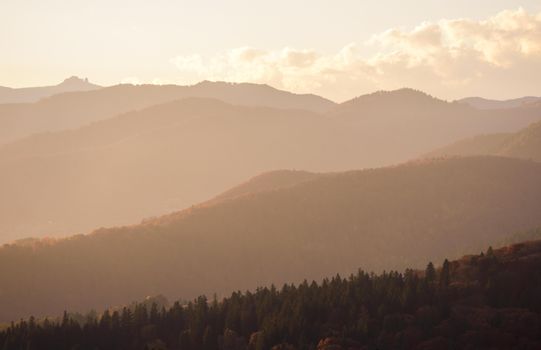 Peaceful view of mountain range with a hazy sunset background creating a tranquil and natural landscape.