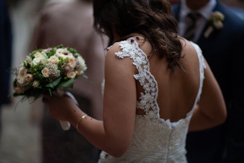 Photo of a Bride Holding a Bouquet of Flowers