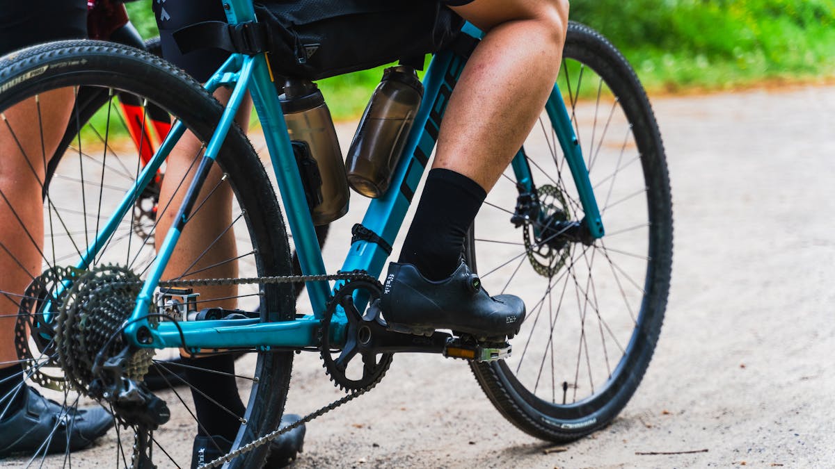 Close-up of a gravel bike with wide tires on a dirt trail