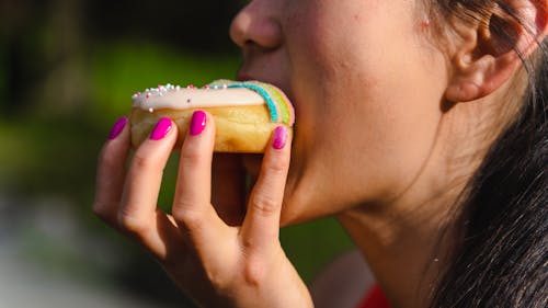 Photo of a Woman Eating a Donut