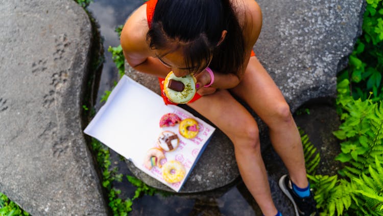 High-Angle Shot Of A Woman Eating A Donut