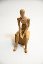 Wooden Human Figurine Sitting on Wooden Block