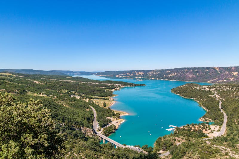 Vue aérienne d'un lac bleu entouré de verdure à Moustiers-Sainte-Marie
