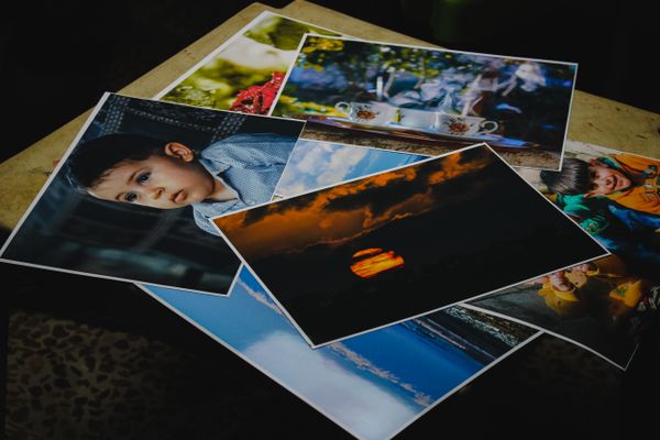 Printed photographs spread across a table — photo by Samer Daboul on Pexels