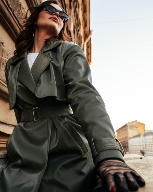 Free Low angle portrait of a fashionable woman in a leather coat and sunglasses, exuding confidence outdoors. Stock Photo