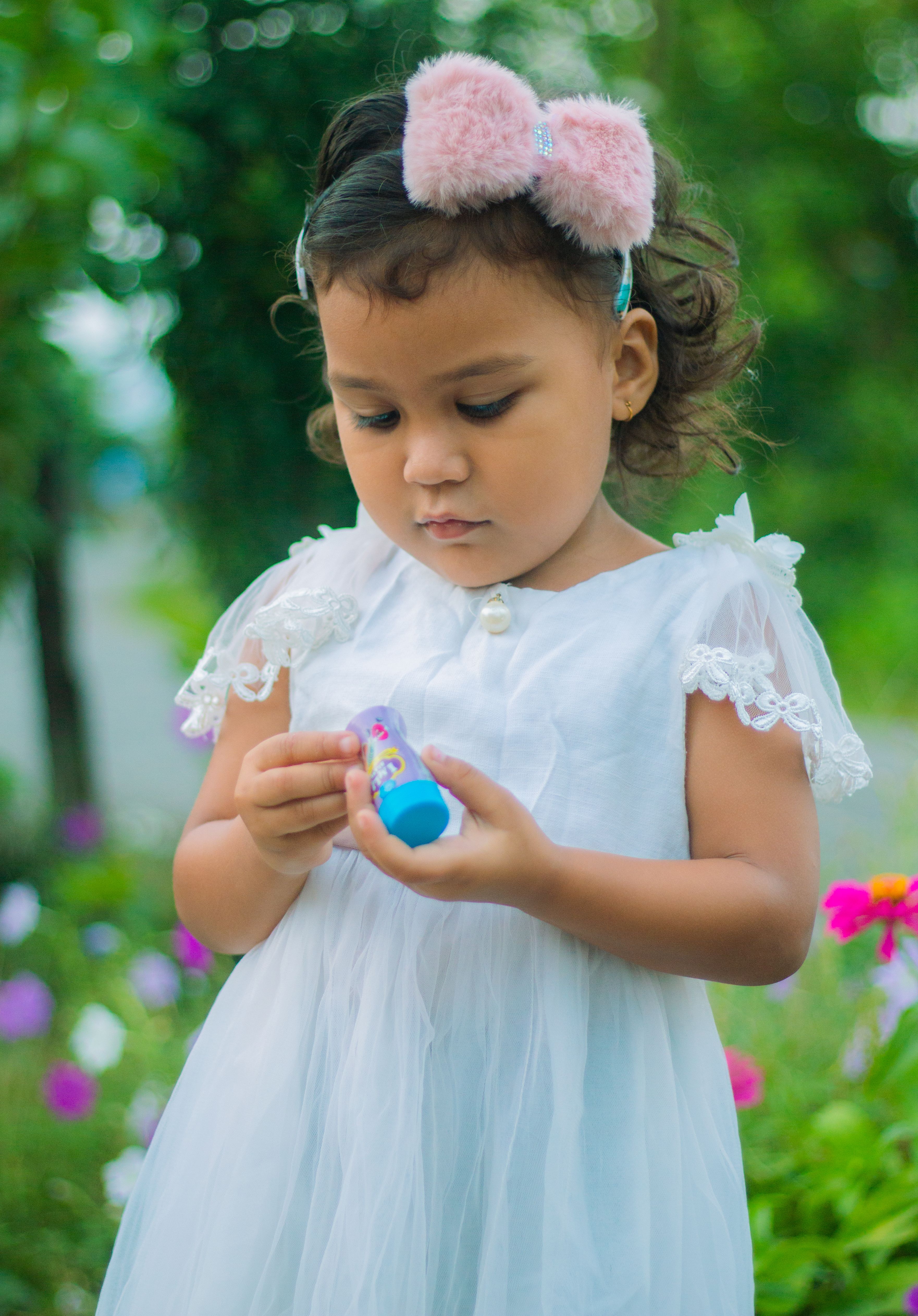Cute Little Girl in a White Dress Holding a Toy · Free Stock Photo