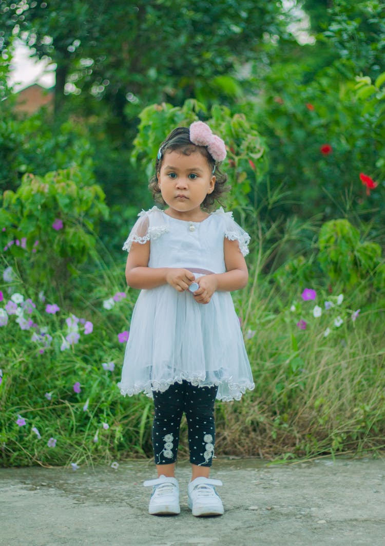 Girl In White Dress Standing On Concrete Pavement