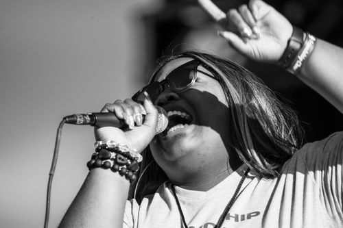 Free Close-up of a woman singing passionately with a microphone on stage wearing sunglasses. Stock Photo