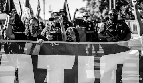 Grayscale Photo of People Holding a Protest