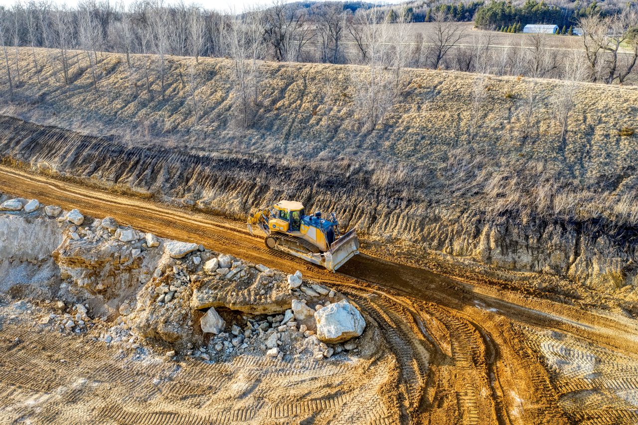 Grader and haulage equipment removing soil from a Melbourne construction site