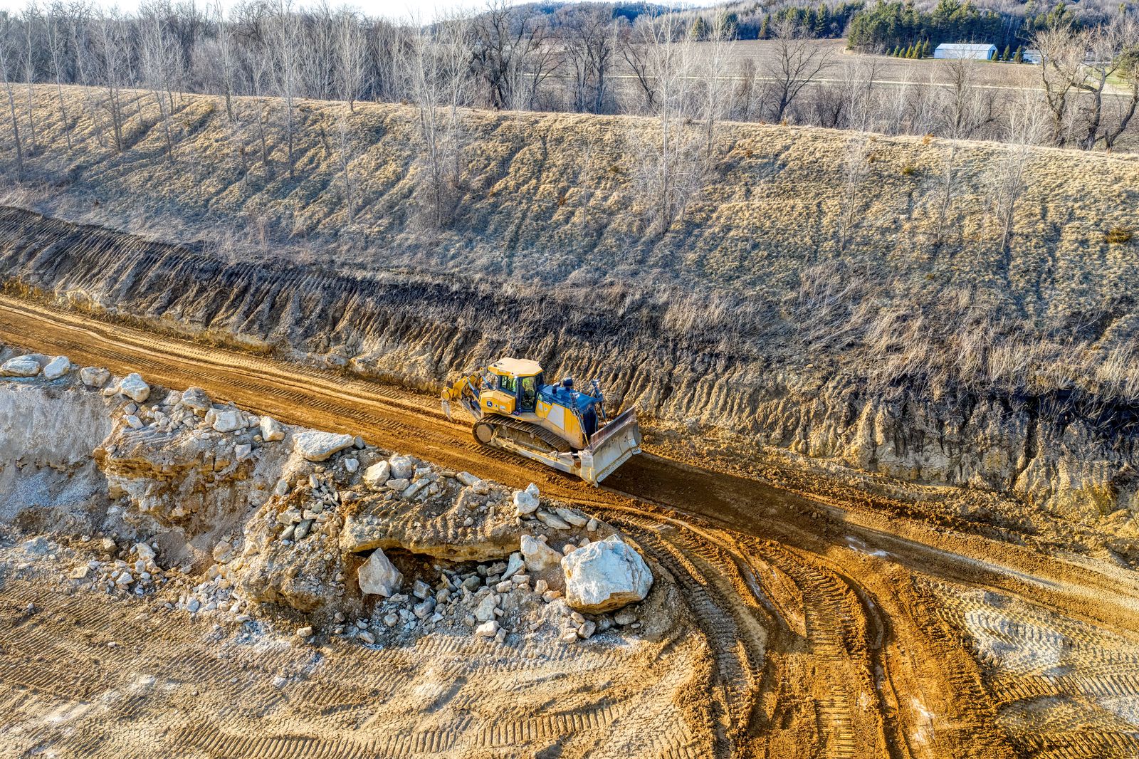 Aerial view of a bulldozer working a dirt road in a quarry