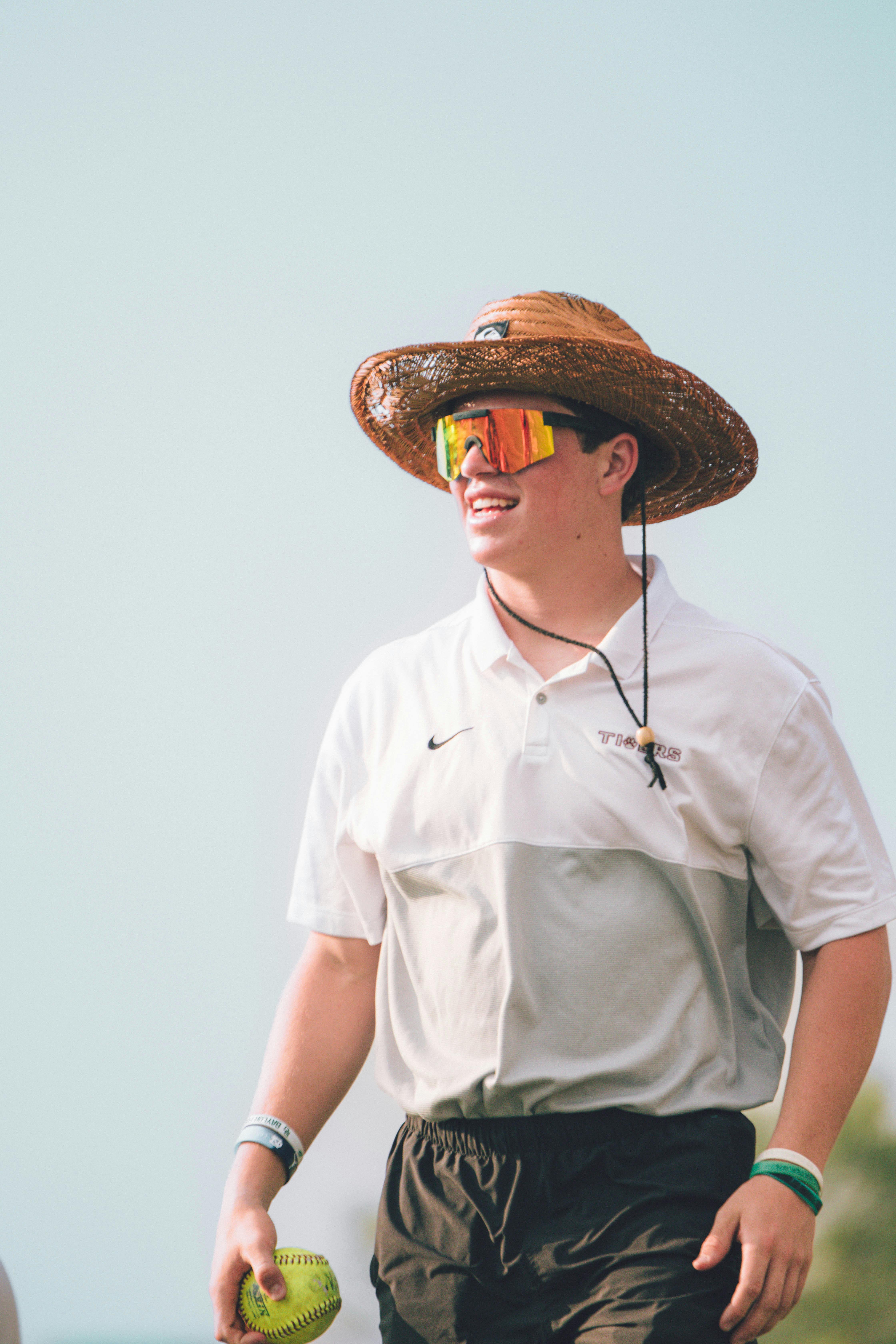 a man in white polo shirt wearing brown hat